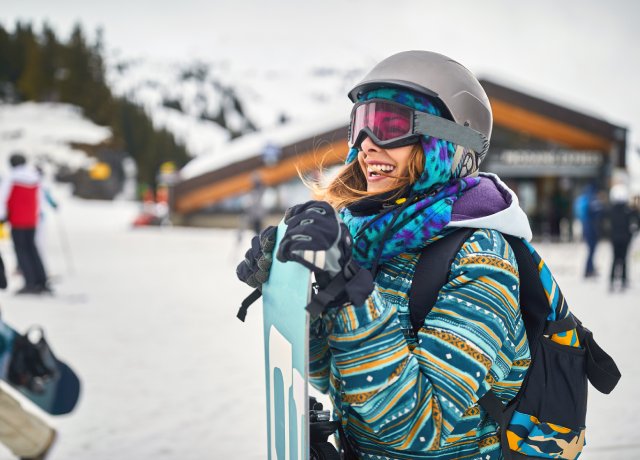 woman on ski field with snowboard