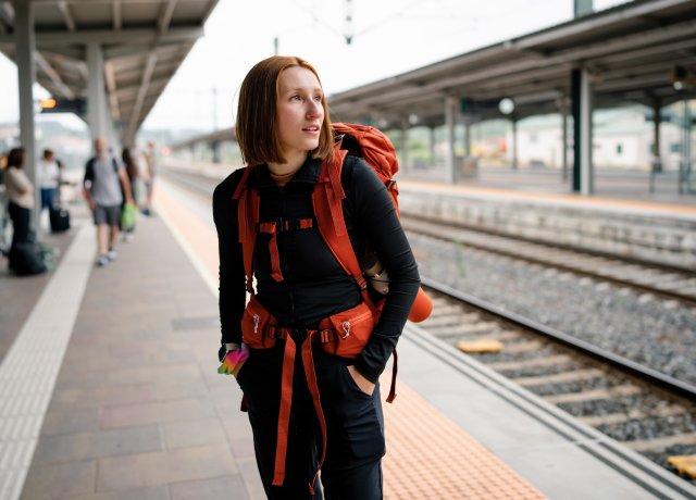 women with backpack on train platform